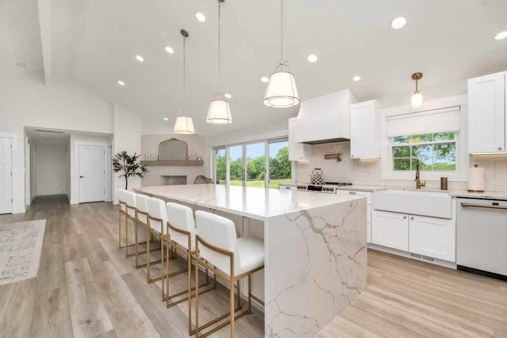 Remodeled kitchen with marble island and white cabinets